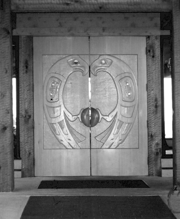 Carved wooden entrance doors featuring two stylized eagles facing each other